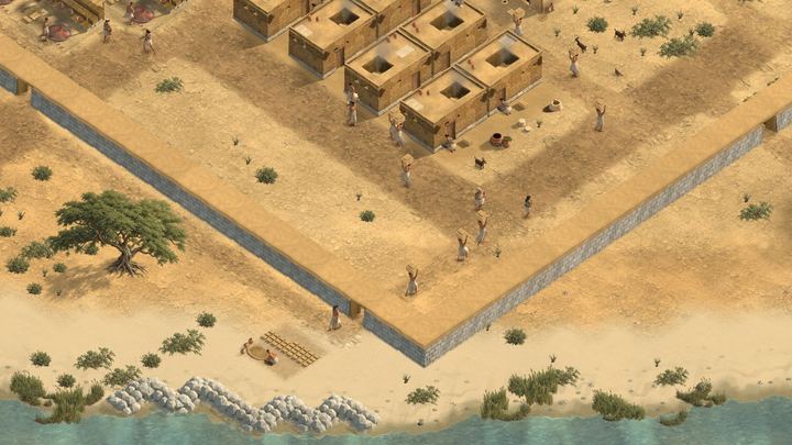 A town wall running along a river, with houses inside.
